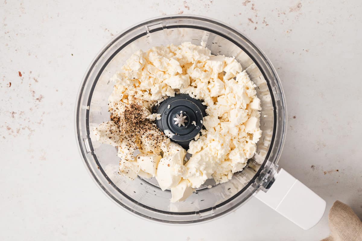 feta, cream cheese, and pepper in bowl of food processor