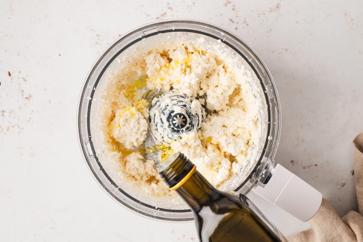 olive oil being drizzled into blended feta