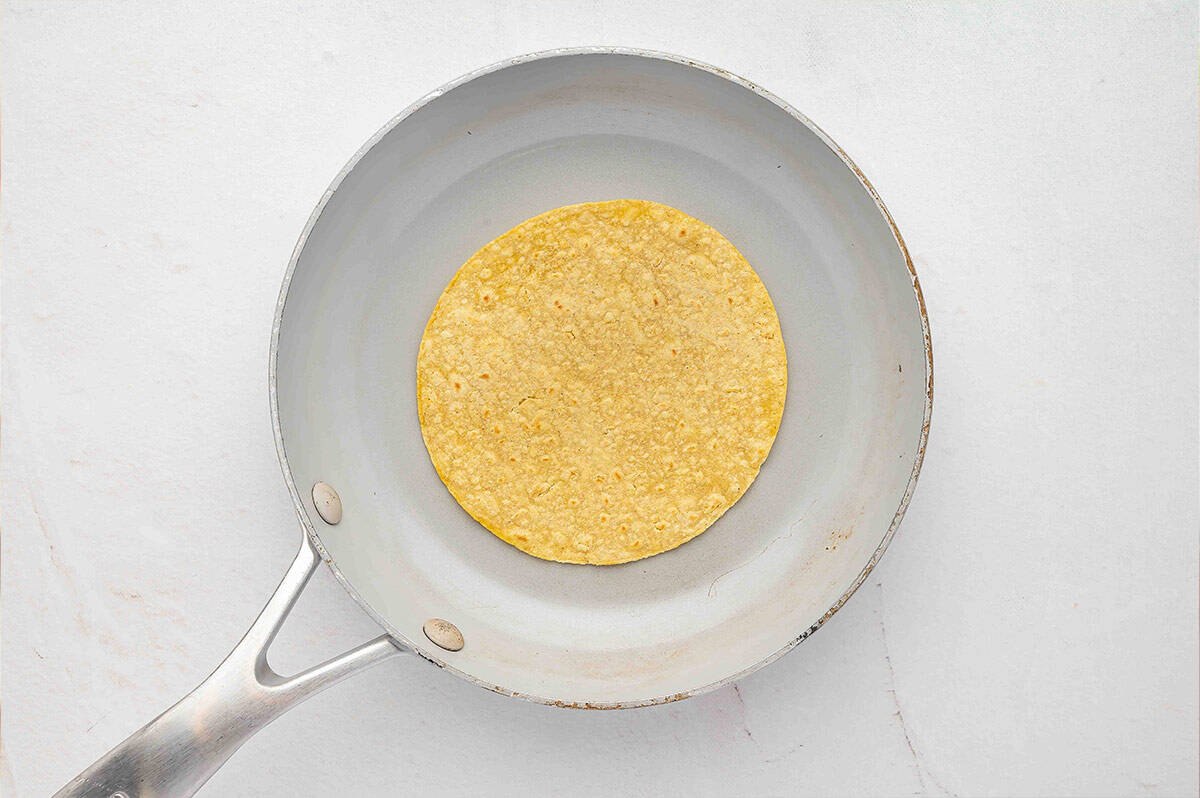 Heating a corn tortilla in a skillet