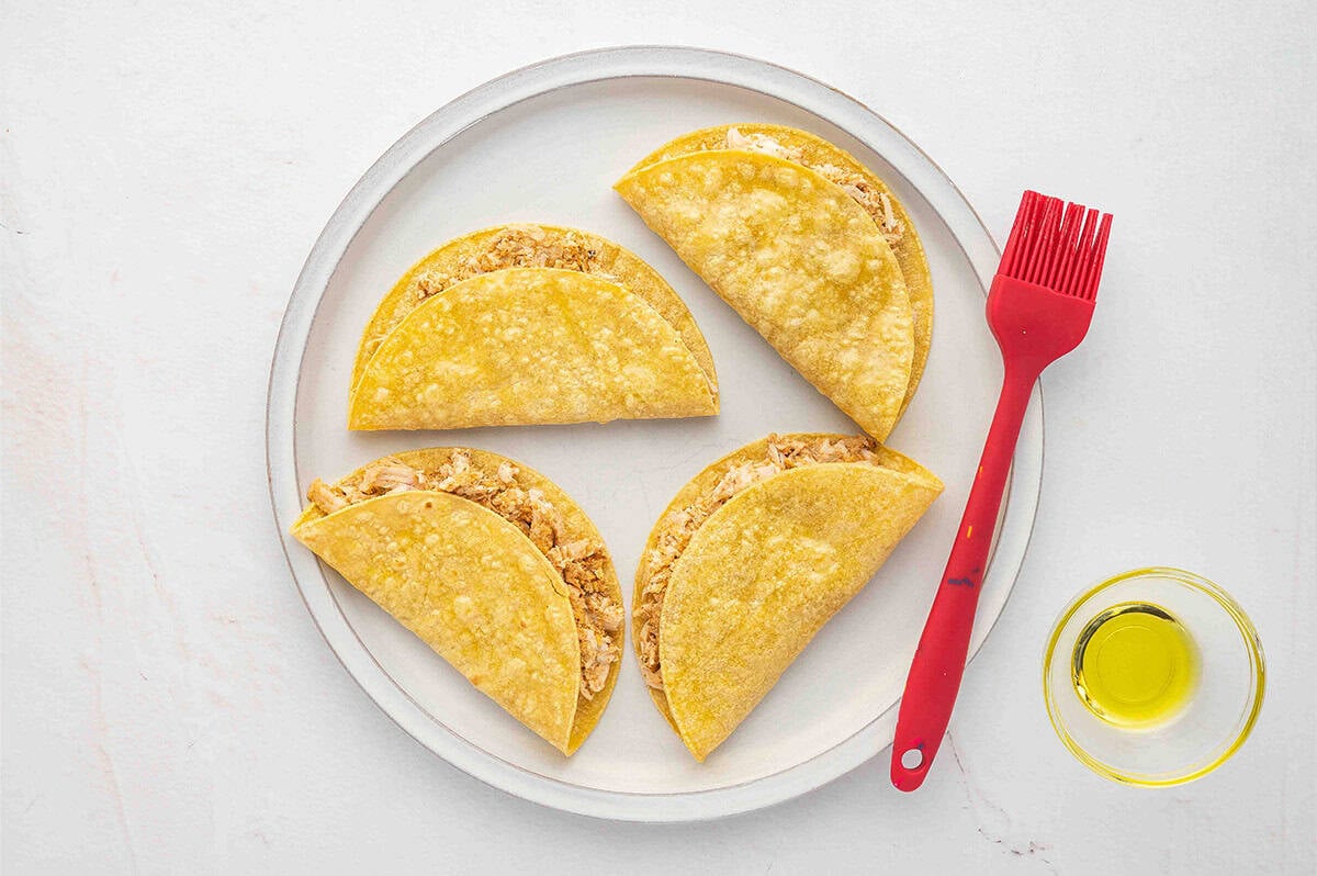 A plate with four air fryer chicken tacos