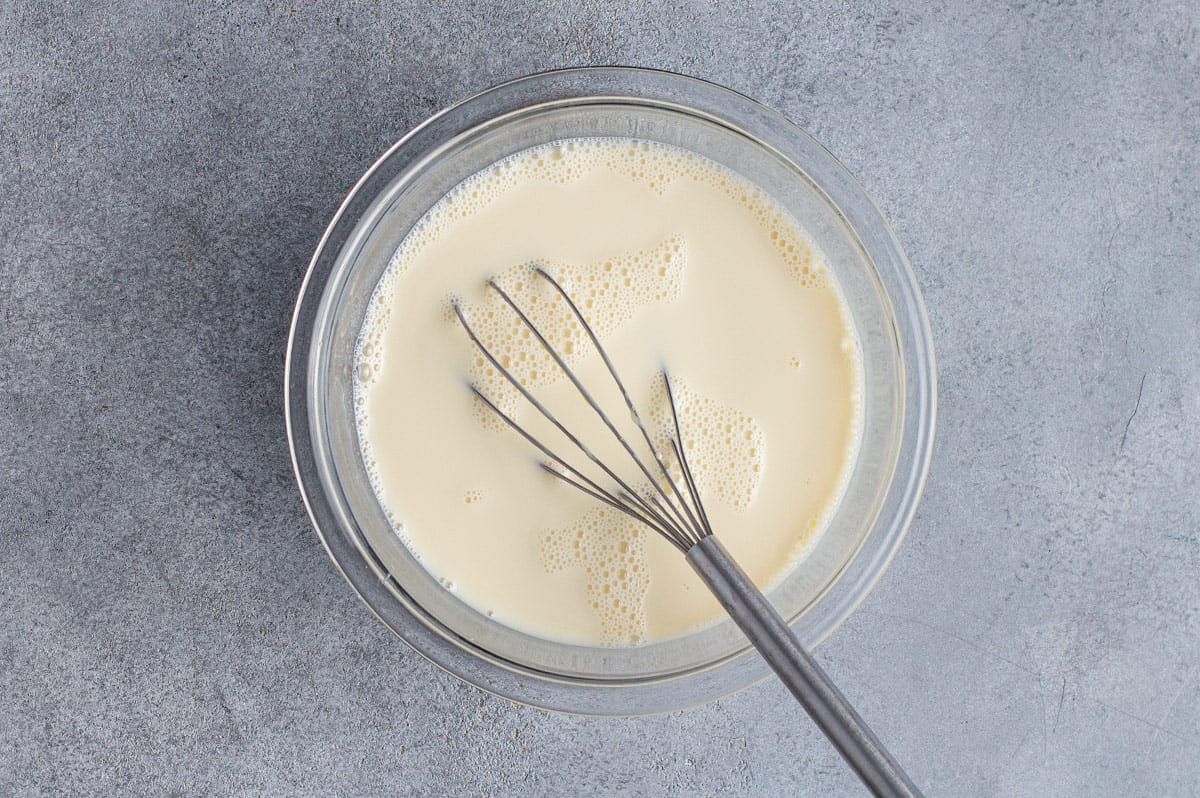 custard mixture in bowl with whisk