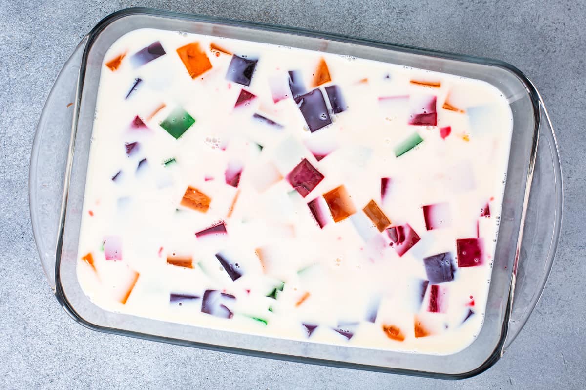 colorful small cubes of jello floating in custard in casserole dish