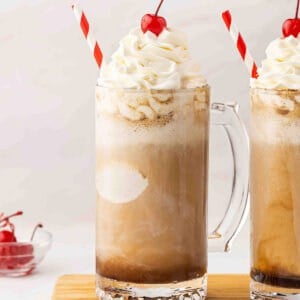 A boozy root beer float topped with whipped cream and a cherry