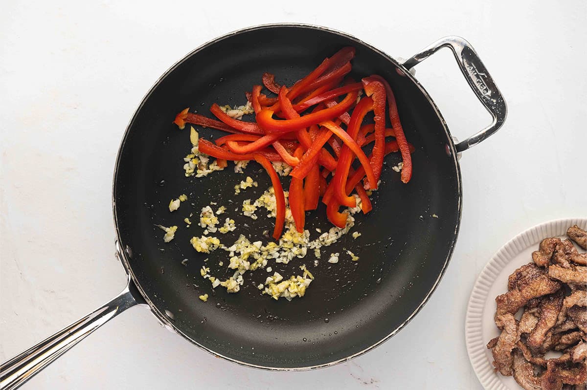 Garlic, ginger, and red bell pepper in a skillet