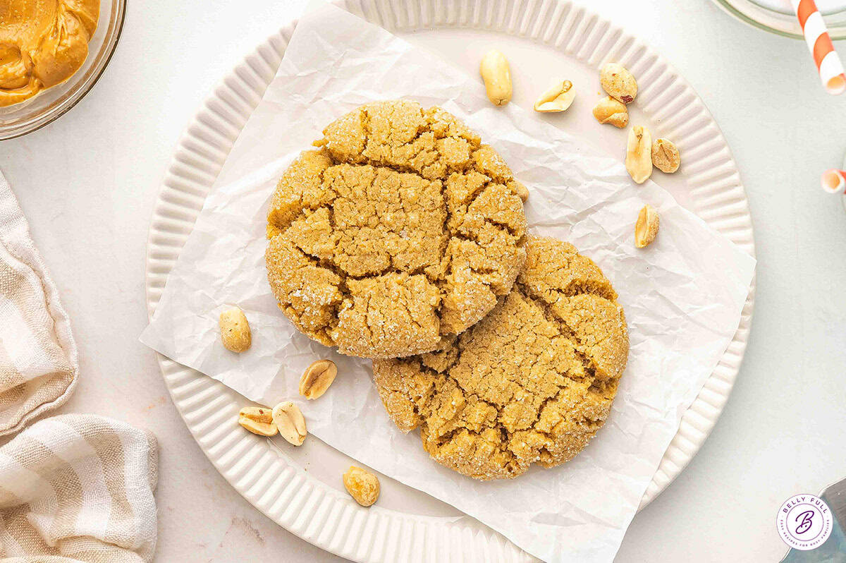 This Peanut Butter Cookies for 2 recipe is the perfect way to satisfy that sweet tooth craving. Soft, chewy cookies in just 15 minutes! Overhead view of two peanut butter cookies on a plate