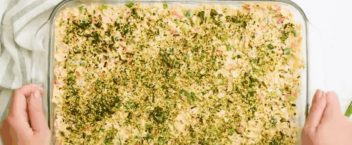 Assembled, unbaked sushi bake in a glass casserole dish.