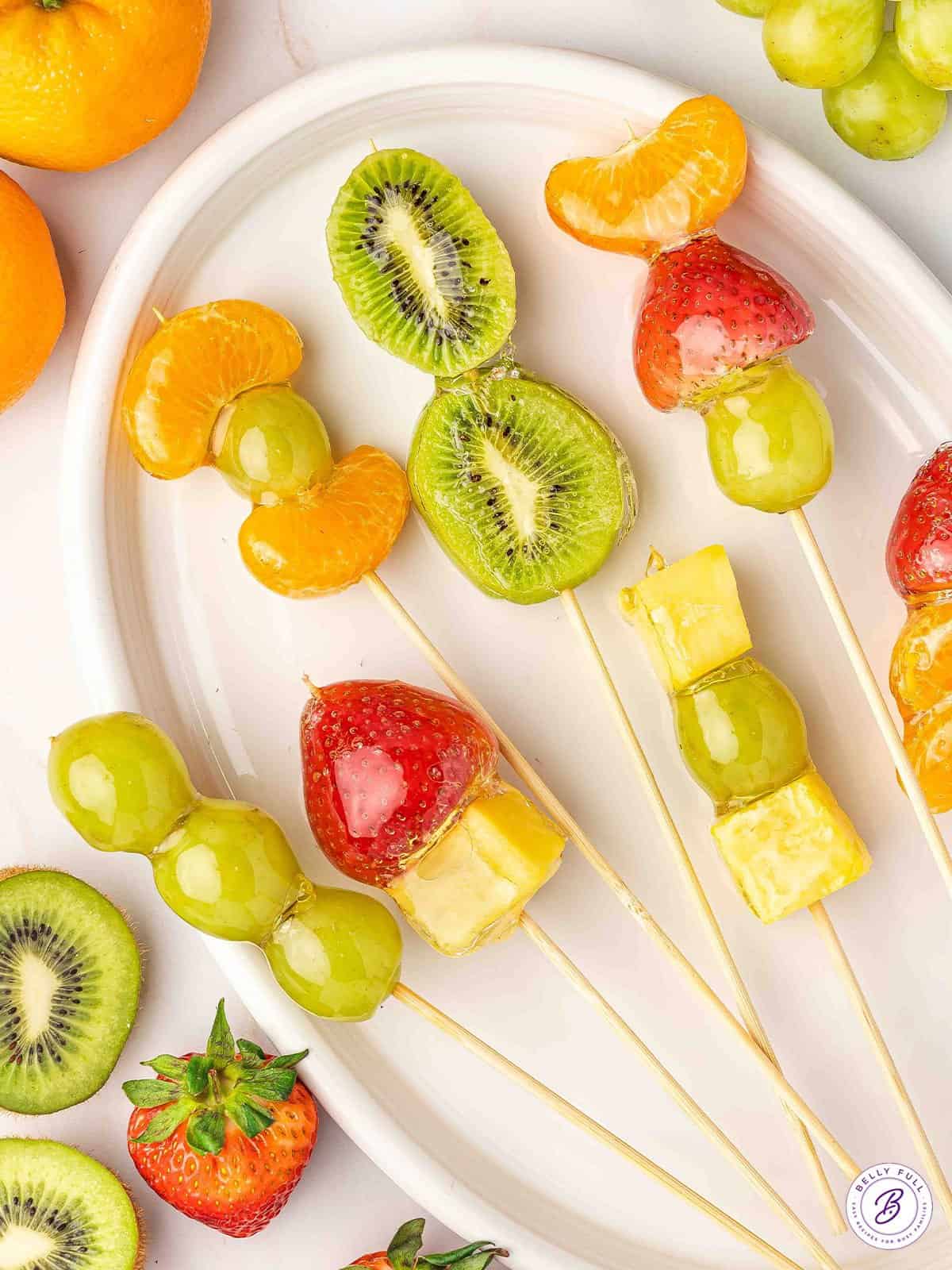 Tanghulu is made with skewers of fresh fruit dipped in a hard sugar coating. Made with just 3 ingredients, it's so simple and easy to make! Tanghulu on a plate