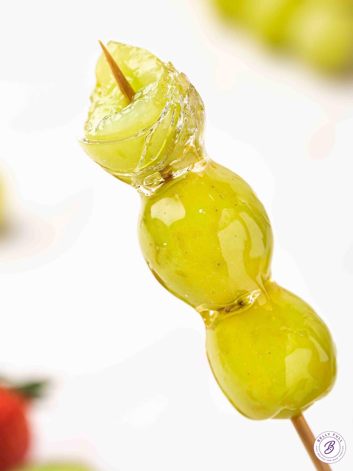 Tanghulu is made with skewers of fresh fruit dipped in a hard sugar coating. Made with just 3 ingredients, it's so simple and easy to make! Close up of grape tanghulu