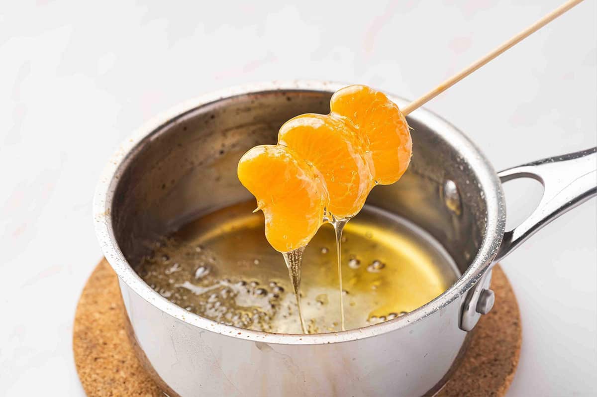 Letting sugar water drip off mandarin tanghulu