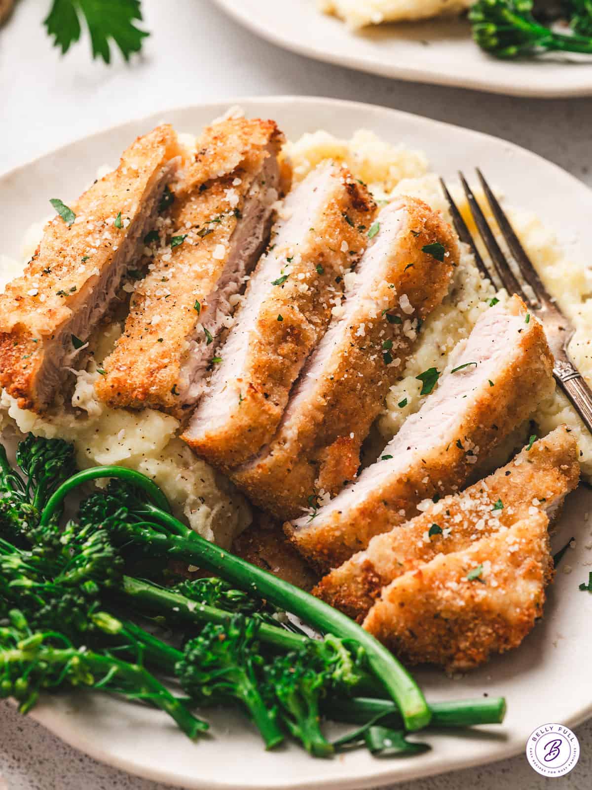 sliced air fryer pork chops on plate with mashed potatoes