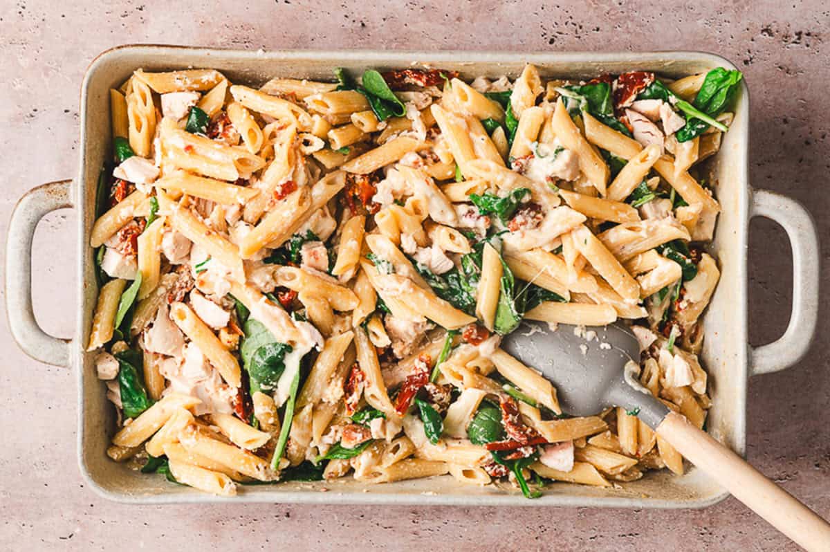 Stirring baked Tuscan chicken pasta