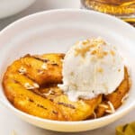grilled pineapple rings in bowl with vanilla ice cream