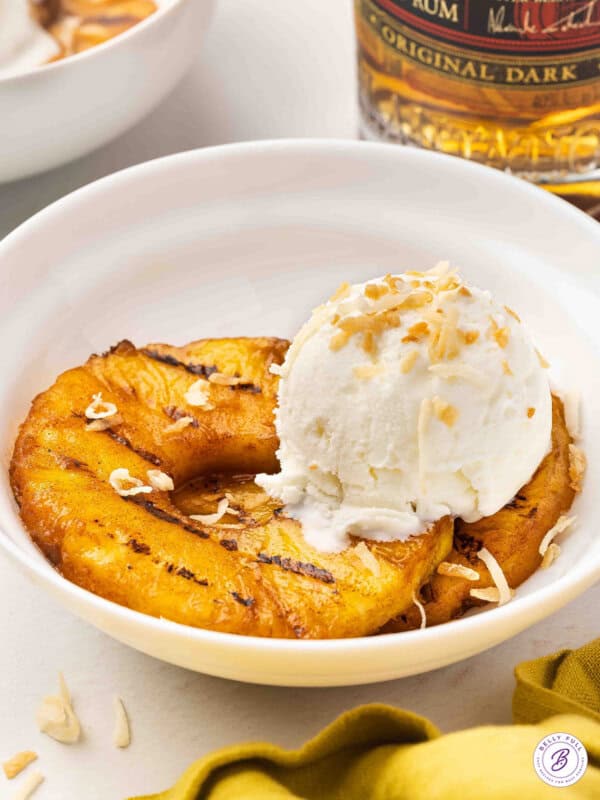 grilled pineapple rings in bowl with vanilla ice cream