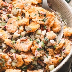 A spoon in a bowl of dill pickle tater tot salad