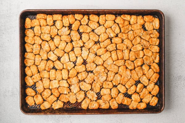 Crispy smashed tater tots on a baking sheet