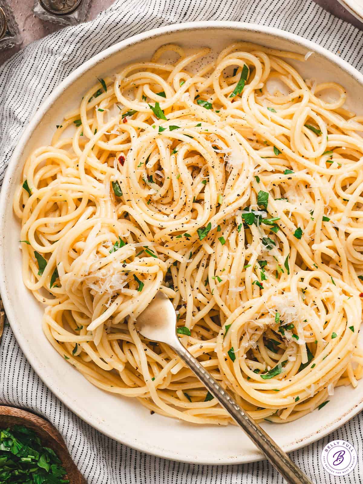 Pasta is tossed with olive oil, garlic, and parmesan cheese in this simple Spaghetti Aglio e Olio recipe. Ready in just 25 minutes! Overhead view of a plate of spaghetti aglio e olio