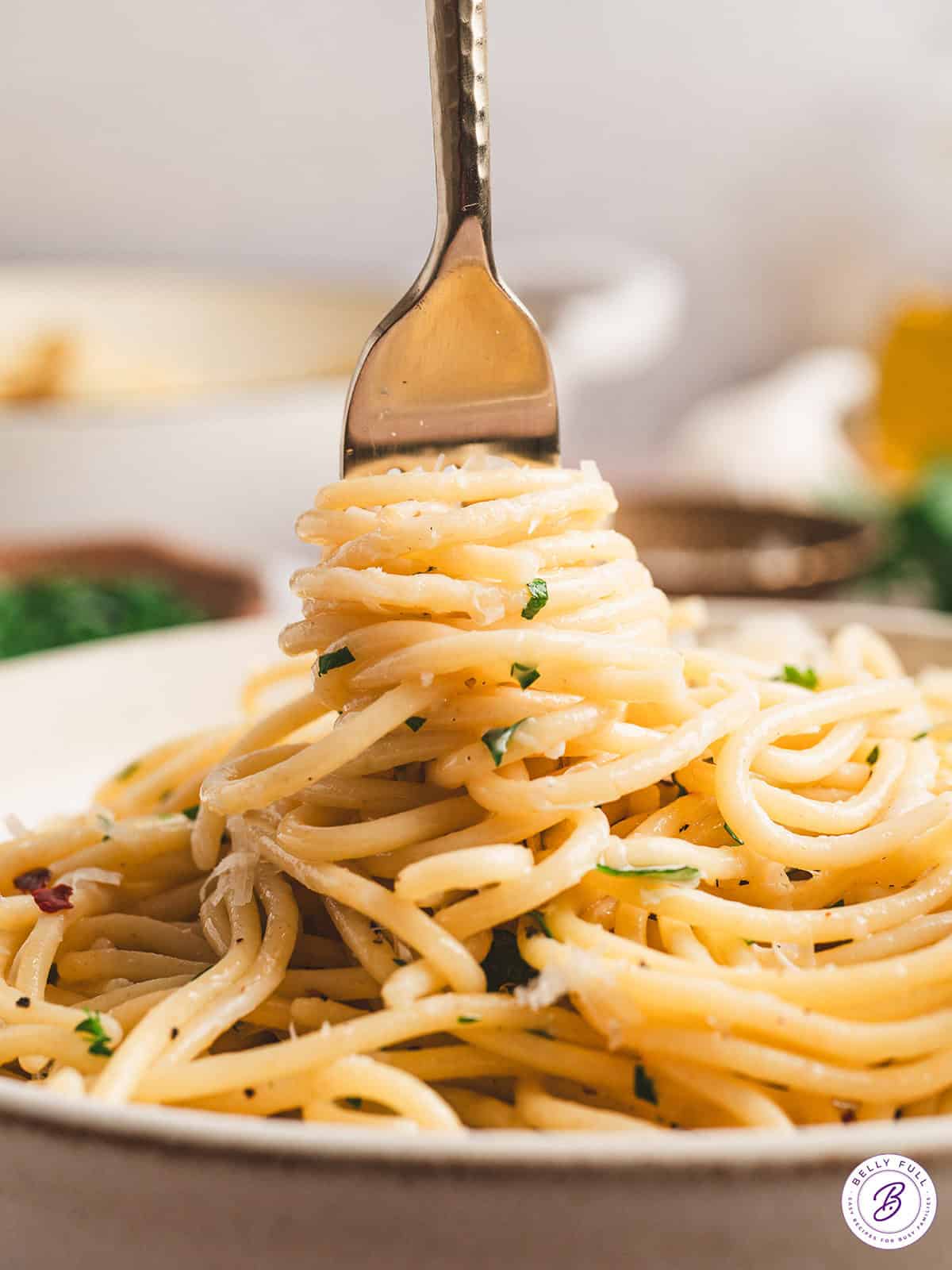 Pasta is tossed with olive oil, garlic, and parmesan cheese in this simple Spaghetti Aglio e Olio recipe. Ready in just 25 minutes! A fork swirling spaghetti aglio e olio