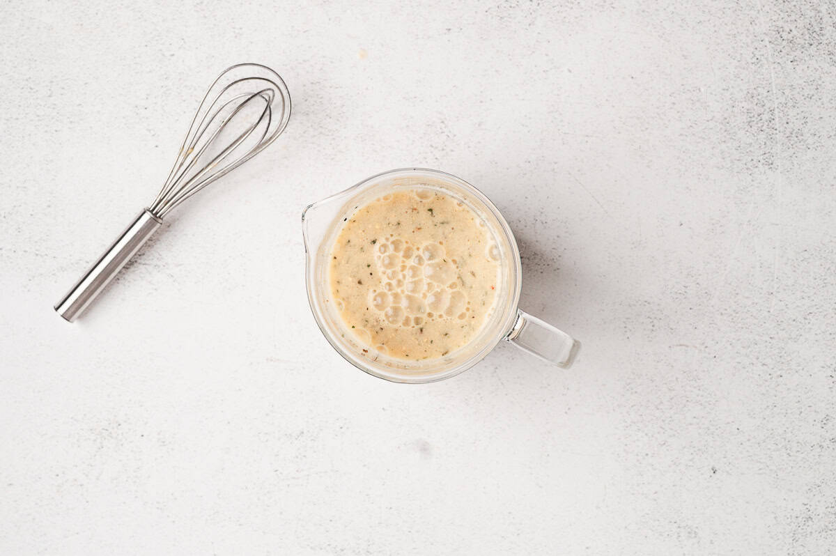Ranch dressing mix, au jus mix, and brown gravy mix sprinkled over the chicken in the slow cooker.
