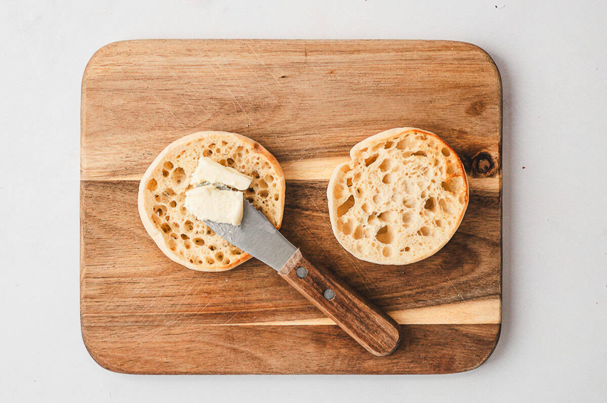A close-up shot of a crispy cheese nest filled with a sunny-side-up egg and topped with chopped herbs.