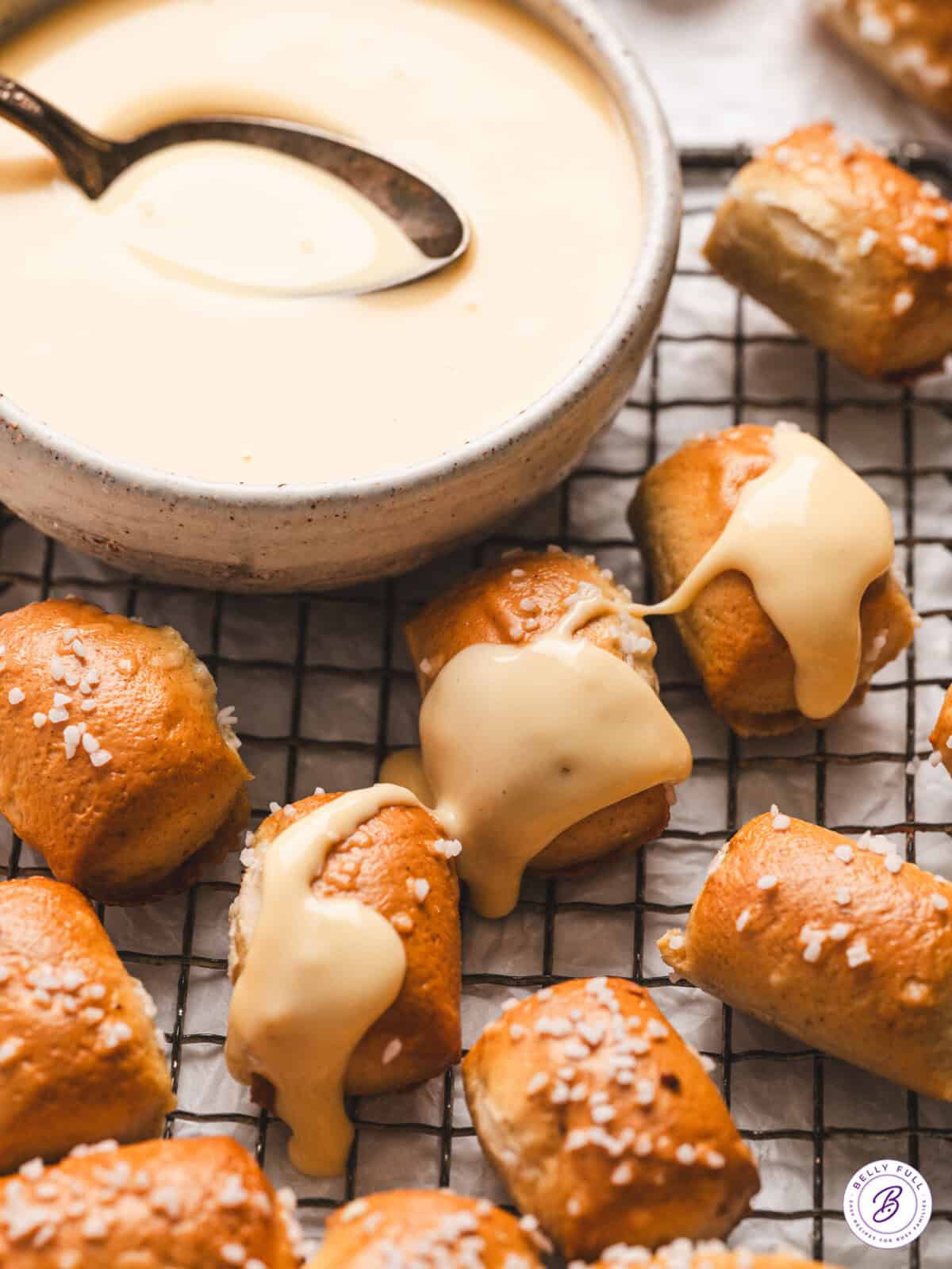 Bowl of rich, velvety cheese sauce surrounded by soft pretzels and tortilla chips.