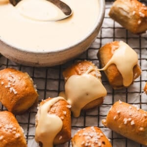 Bowl of rich, velvety cheese sauce surrounded by soft pretzels and tortilla chips.