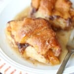 Golden peach dumplings with crescent roll dough on plate