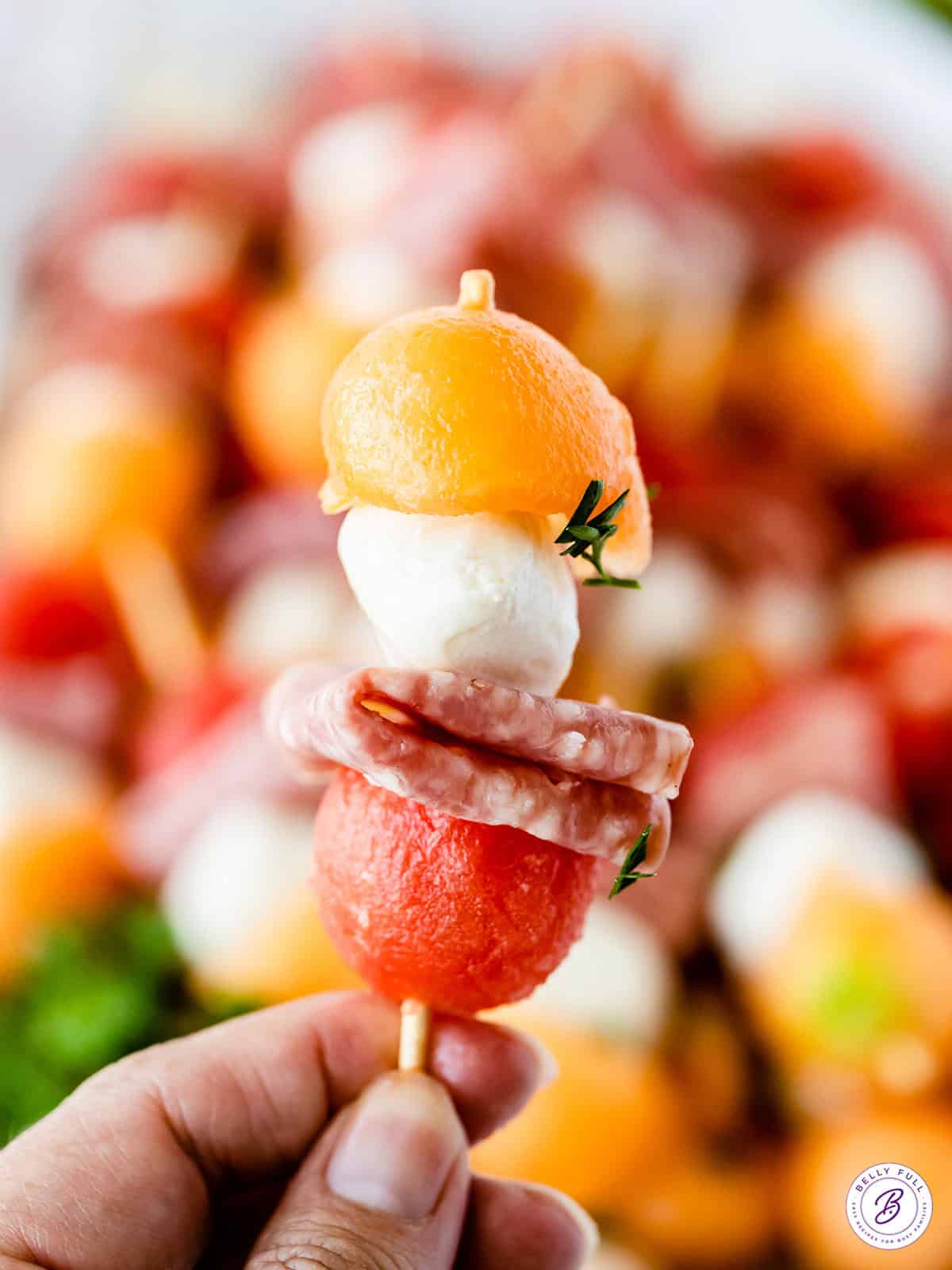 hand holding a mini fruit kabob