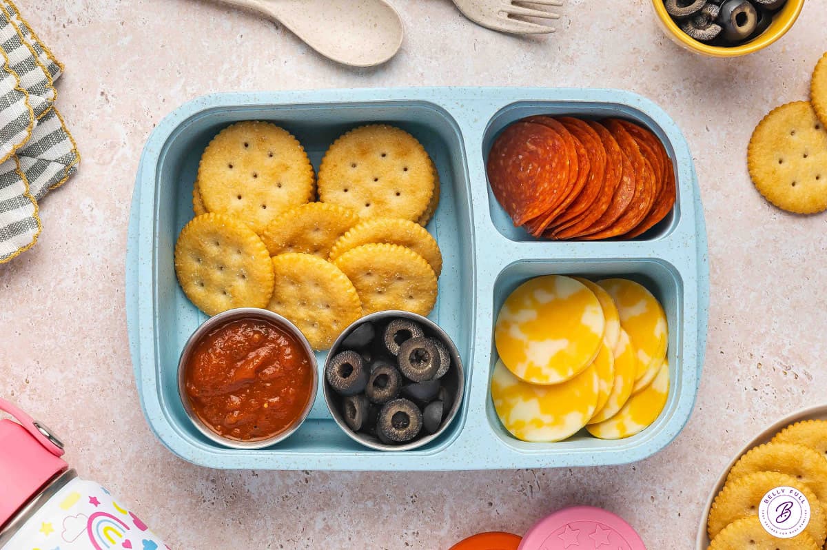 Build your own pizza bento box with Ritz crackers, pepperoni, Colby Jack cheese, black olives, and marinara sauce