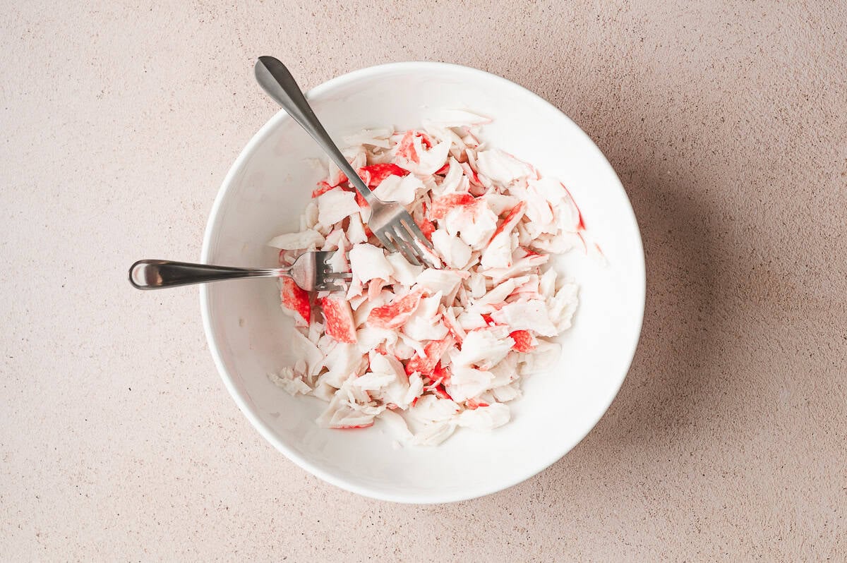 imitation flaked crab meat in bowl with 2 forks