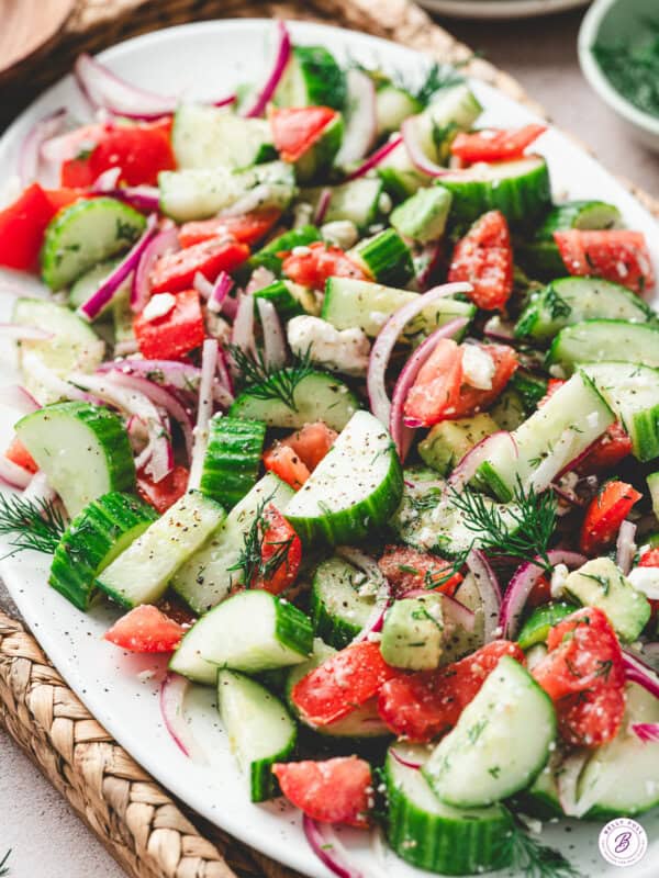 Cucumber Tomato Salad with dill and avocado on serving plate