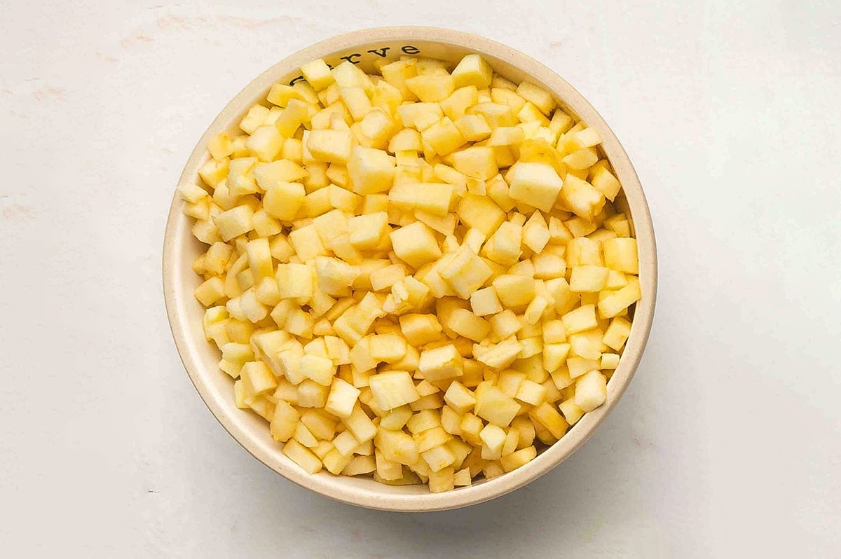 A bowl filled with peeled, cored, and finely chopped Honeycrisp apples.