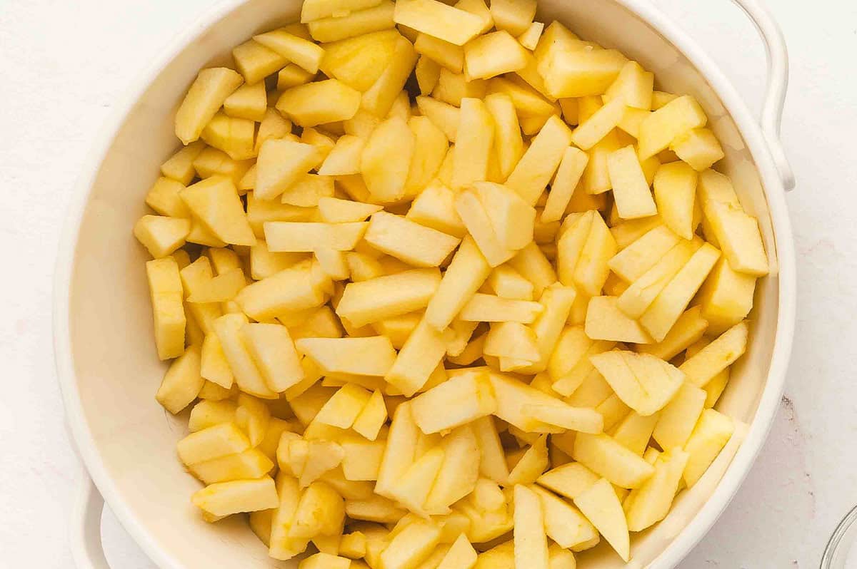Bowl filled with peeled and chopped apples ready for cooking.