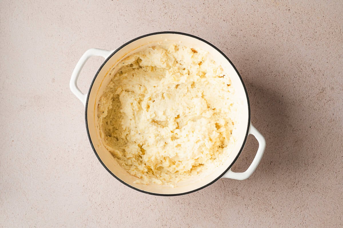 Pot of freshly mashed potatoes mixed until creamy and smooth.
