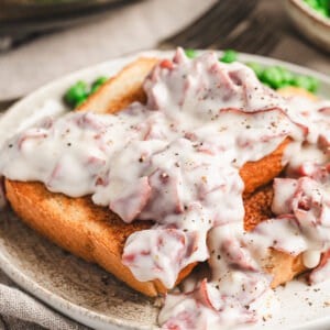 Thick slices of golden toasted bread topped with creamy white gravy and pieces of chipped beef, finished with cracked black pepper.