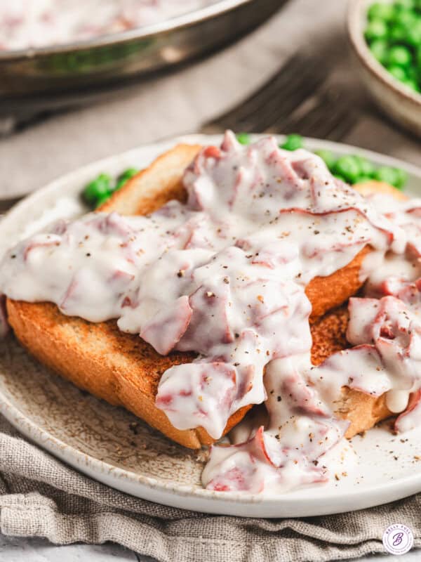 Thick slices of golden toasted bread topped with creamy white gravy and pieces of chipped beef, finished with cracked black pepper.