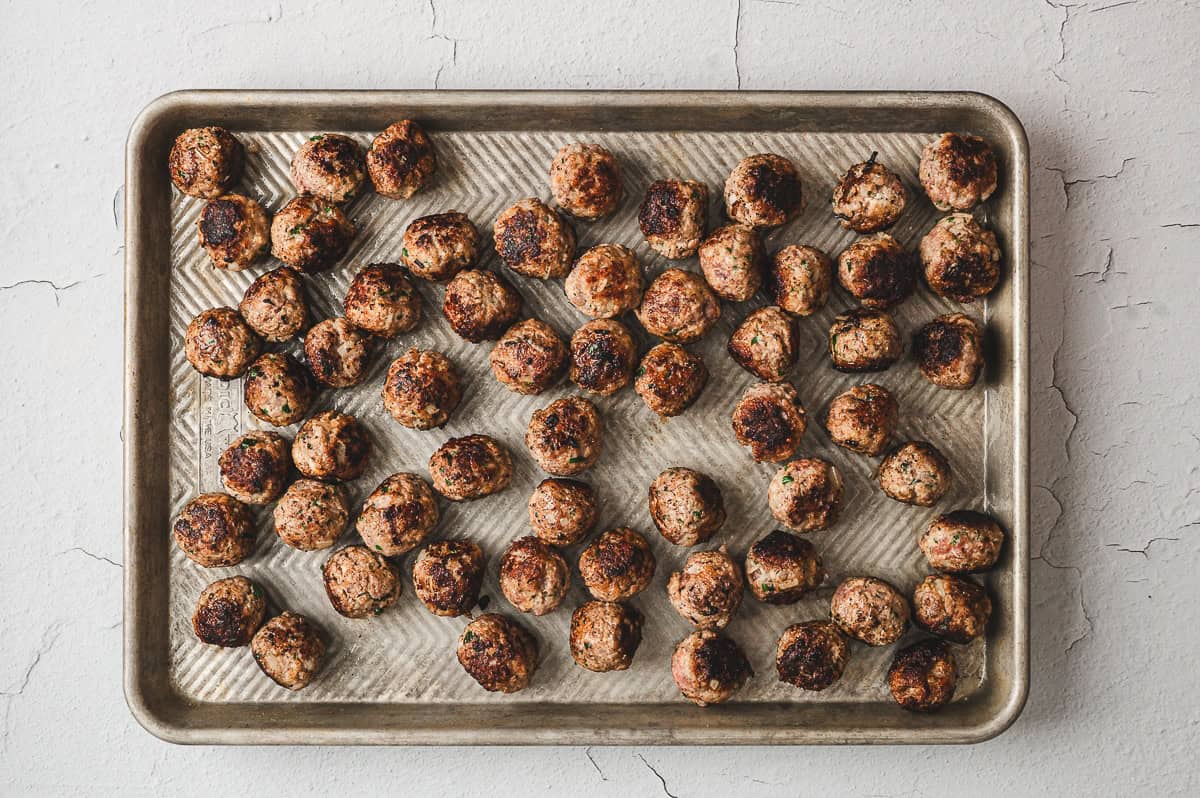 pan fried meatballs in single layer on baking sheet