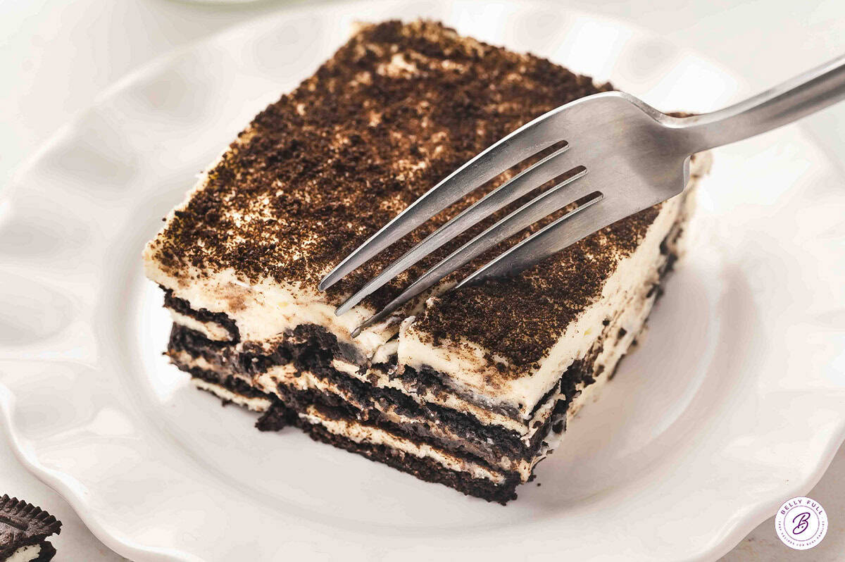 Oreo tiramisu served on a plate with a fork biting into it