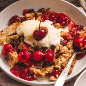 Cherry Dump Cake in bowl with vanilla ice cream