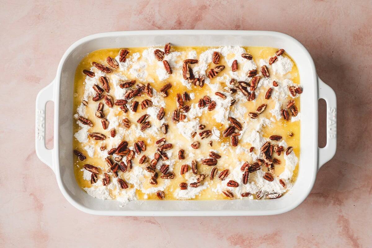chopped pecans and melted butter drizzled over yellow cake mix in casserole dish