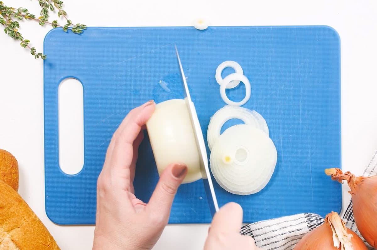 onions being sliced on cutting board