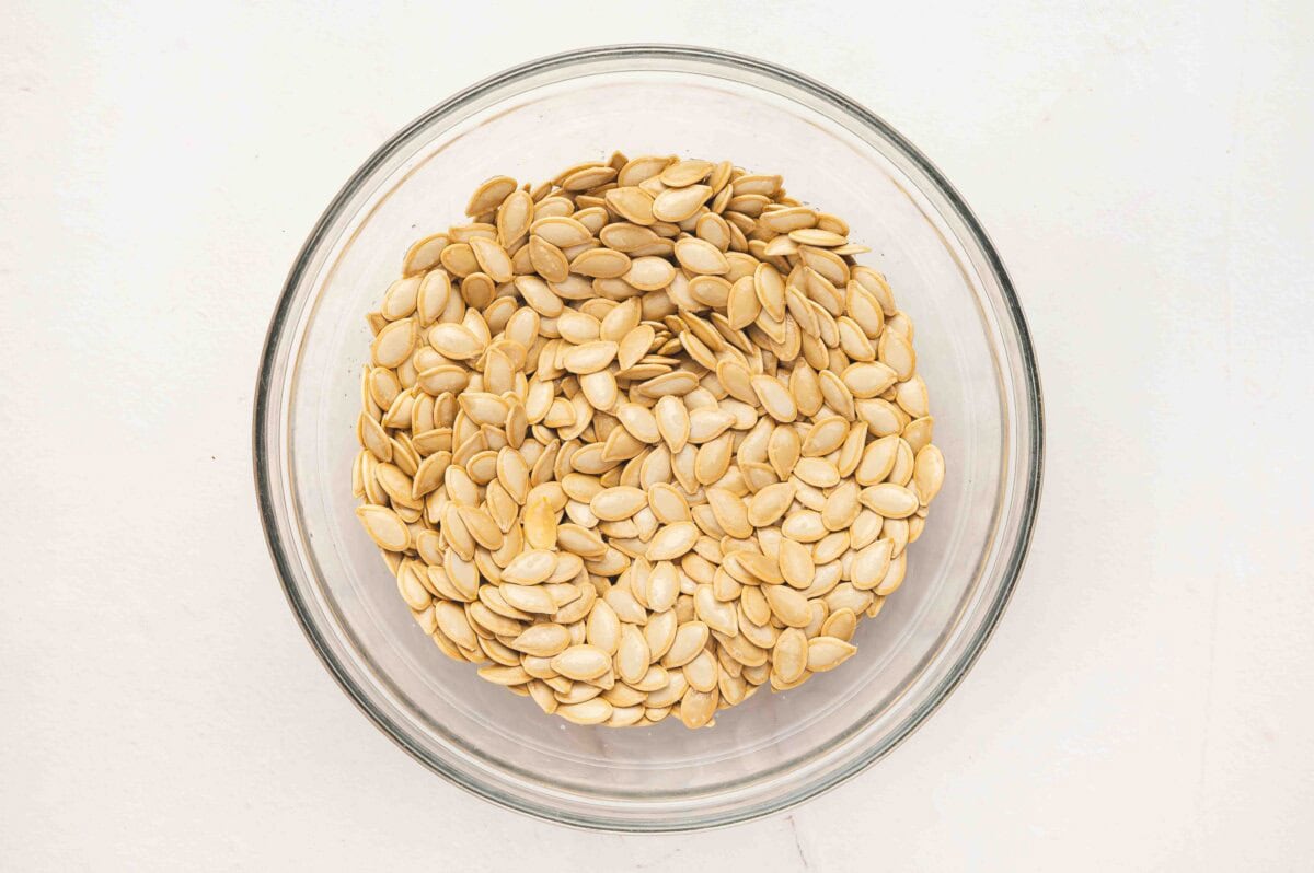 Soaked pumpkin seeds in a glass bowl.