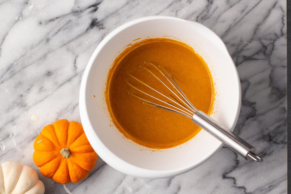 pumpkin pie filling in bowl with whisk
