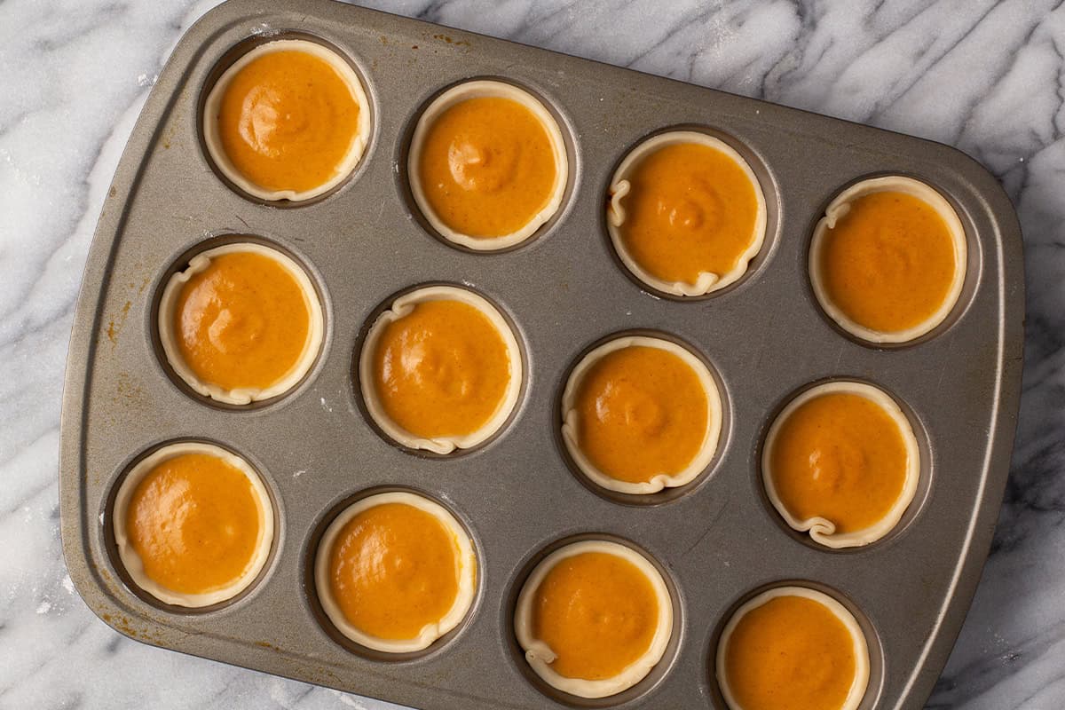 mini pies filled with pumpkin pie filling in muffin tin