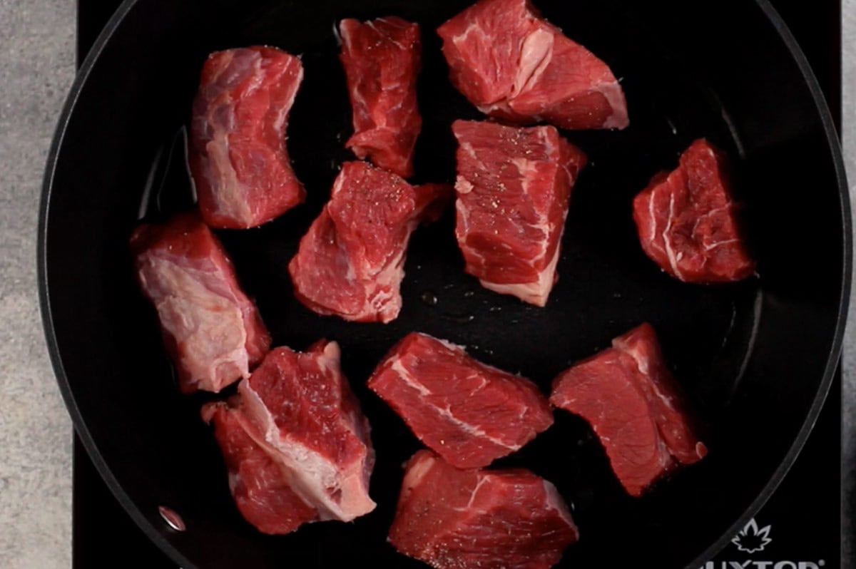 stew meat being browned in skillet