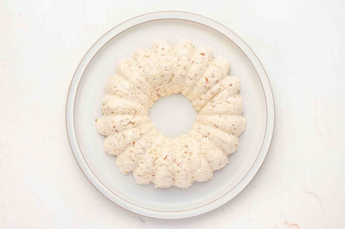 Uncoated cheese ball wreath placed on a serving plate after being removed from the Bundt pan.