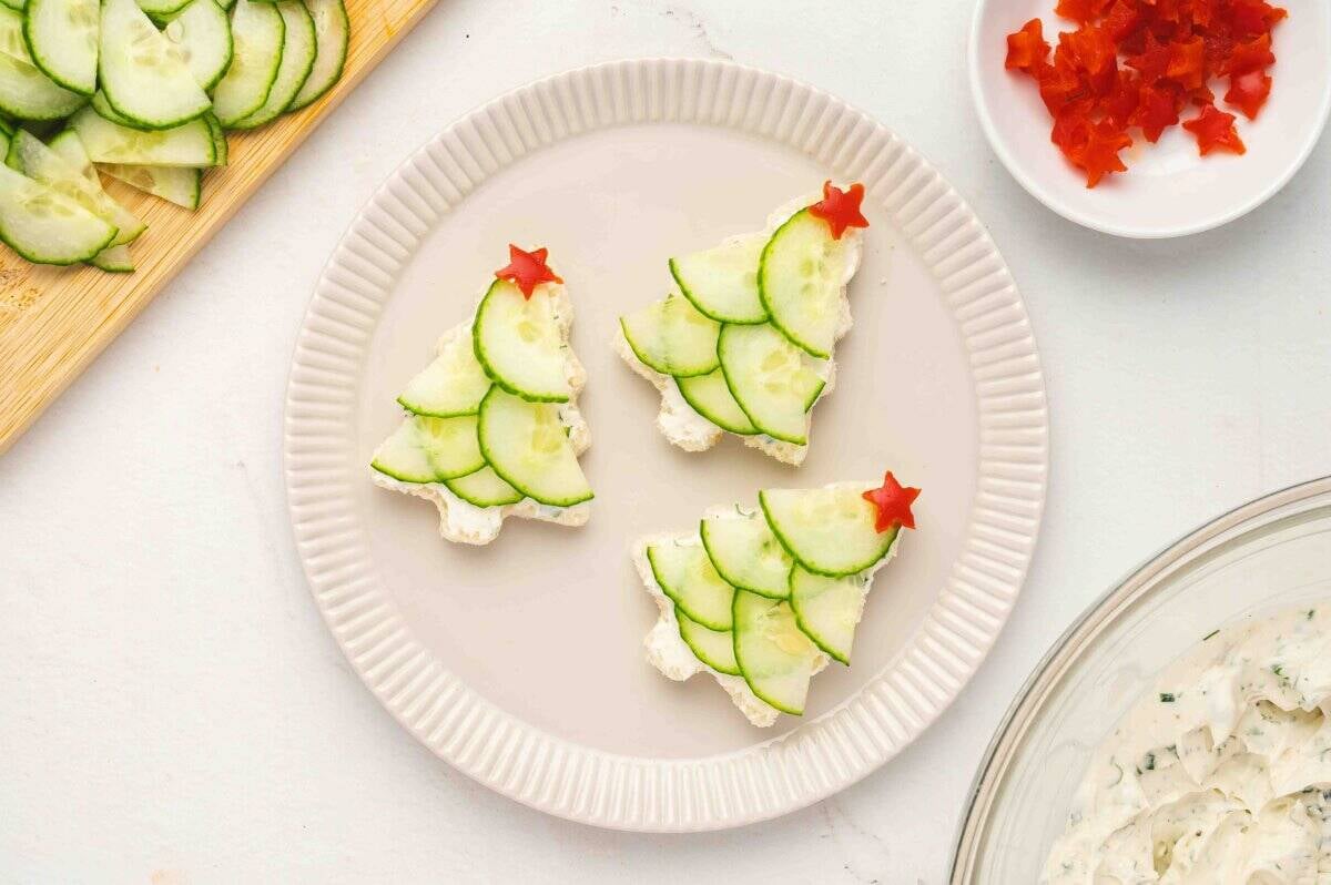 Finished sandwiches topped with red bell pepper stars arranged neatly on a plate.