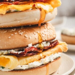Bee sting bagel stacked with bacon, creamy eggs, jalapeño cream cheese, and melted cheese, drizzled with hot honey