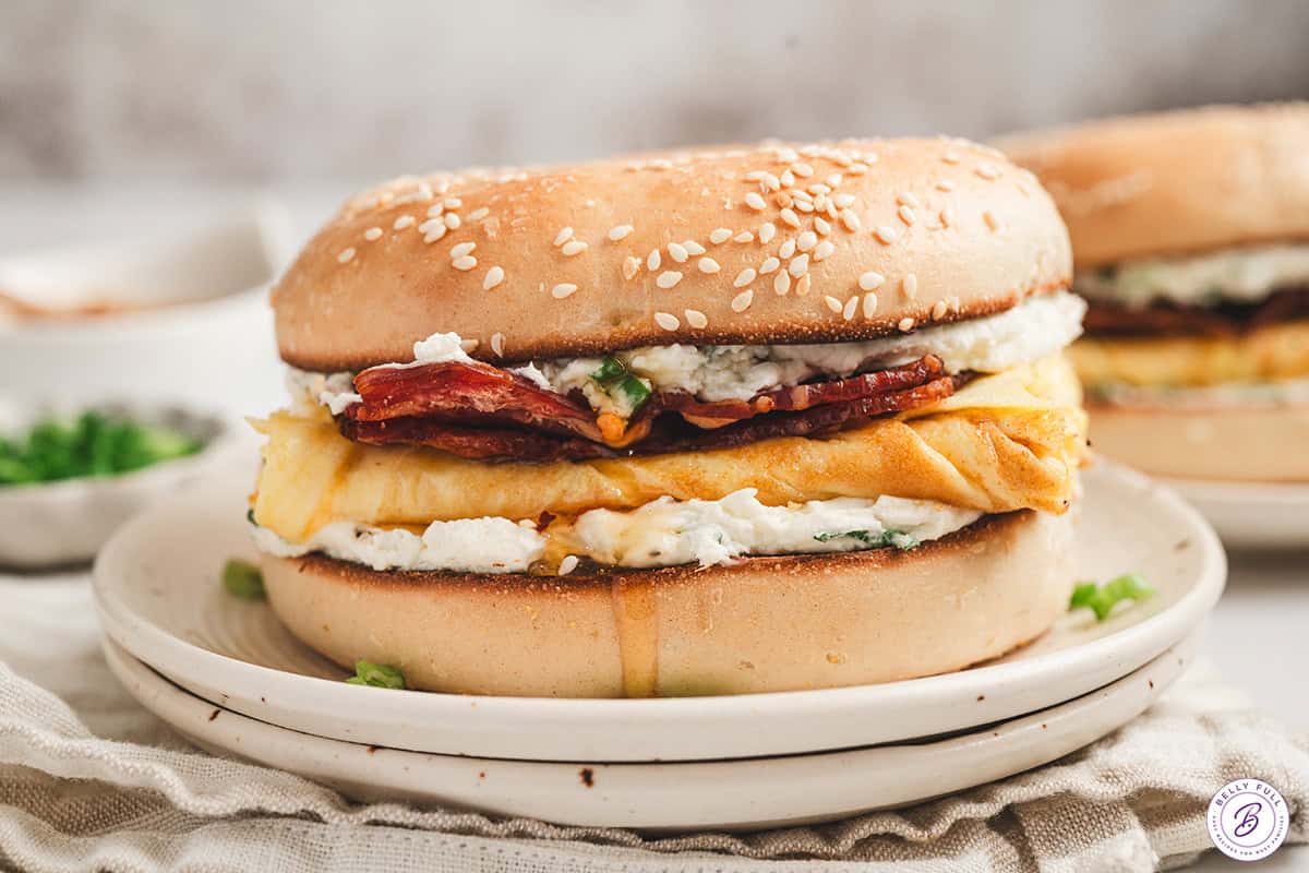 Finished bee sting bagel breakfast sandwich served on a plate with sweet and savory layers visible
