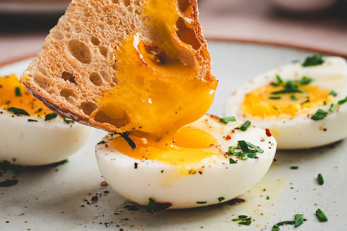bread dipping into the center of a jammy egg