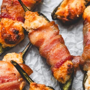 close up roasted Bacon Wrapped Jalapeno Poppers on parchment paper
